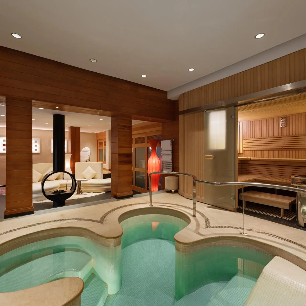 Salle de spa avec piscine d'eau chaude, sauna et espace de repos en bois