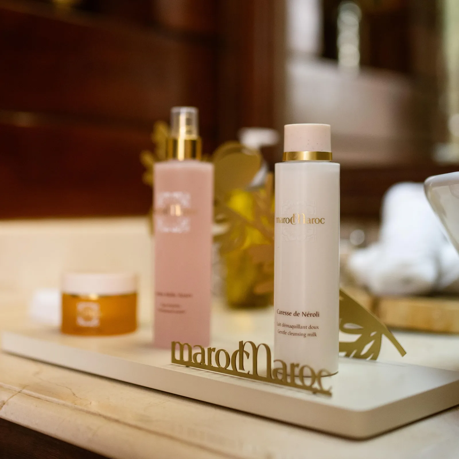 Deux flacons de produits cosmétiques de la marque MarocMaroc posés sur une surface en marbre