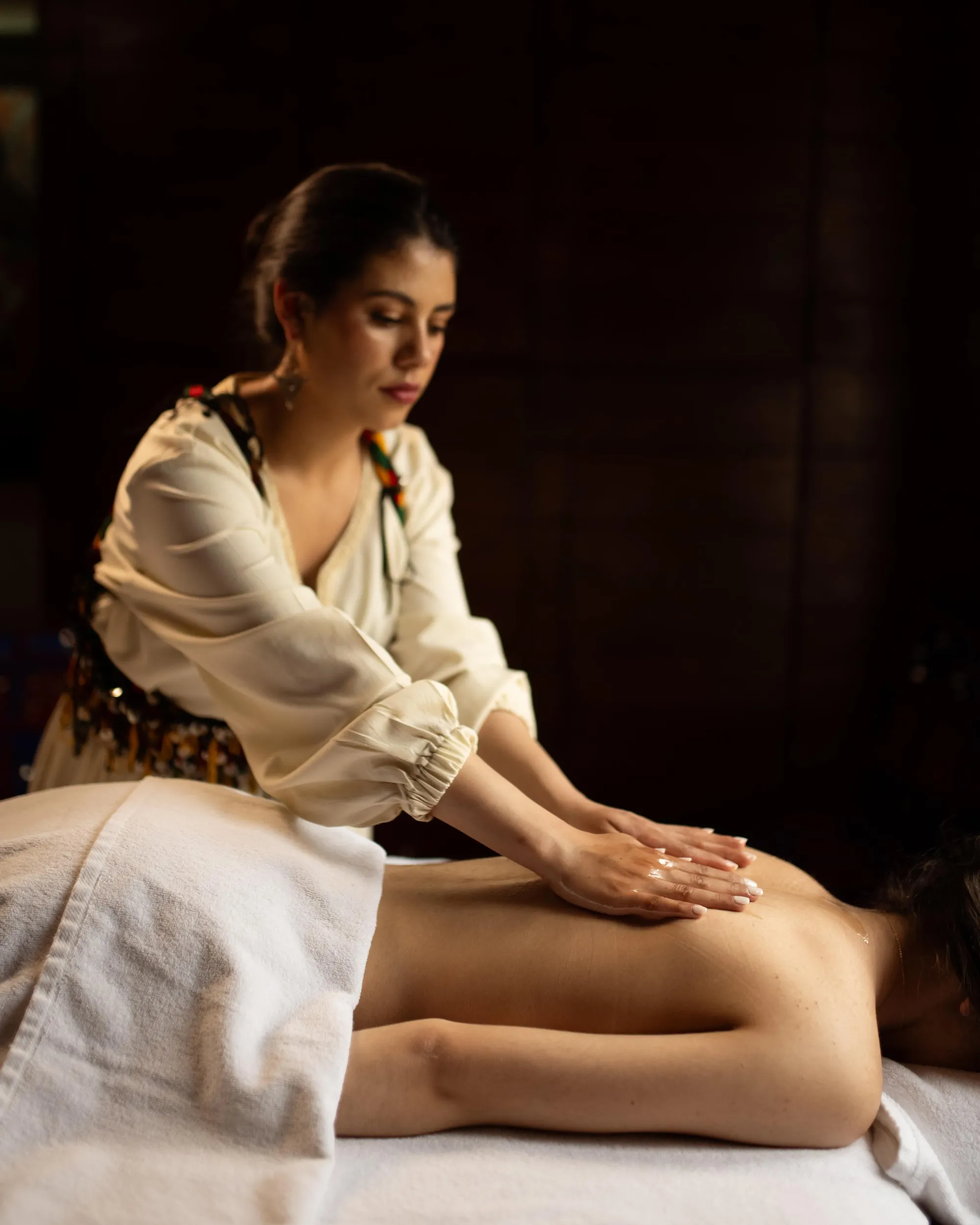 Une personne effectue un massage sur le dos d'une autre personne allongée sur le ventre