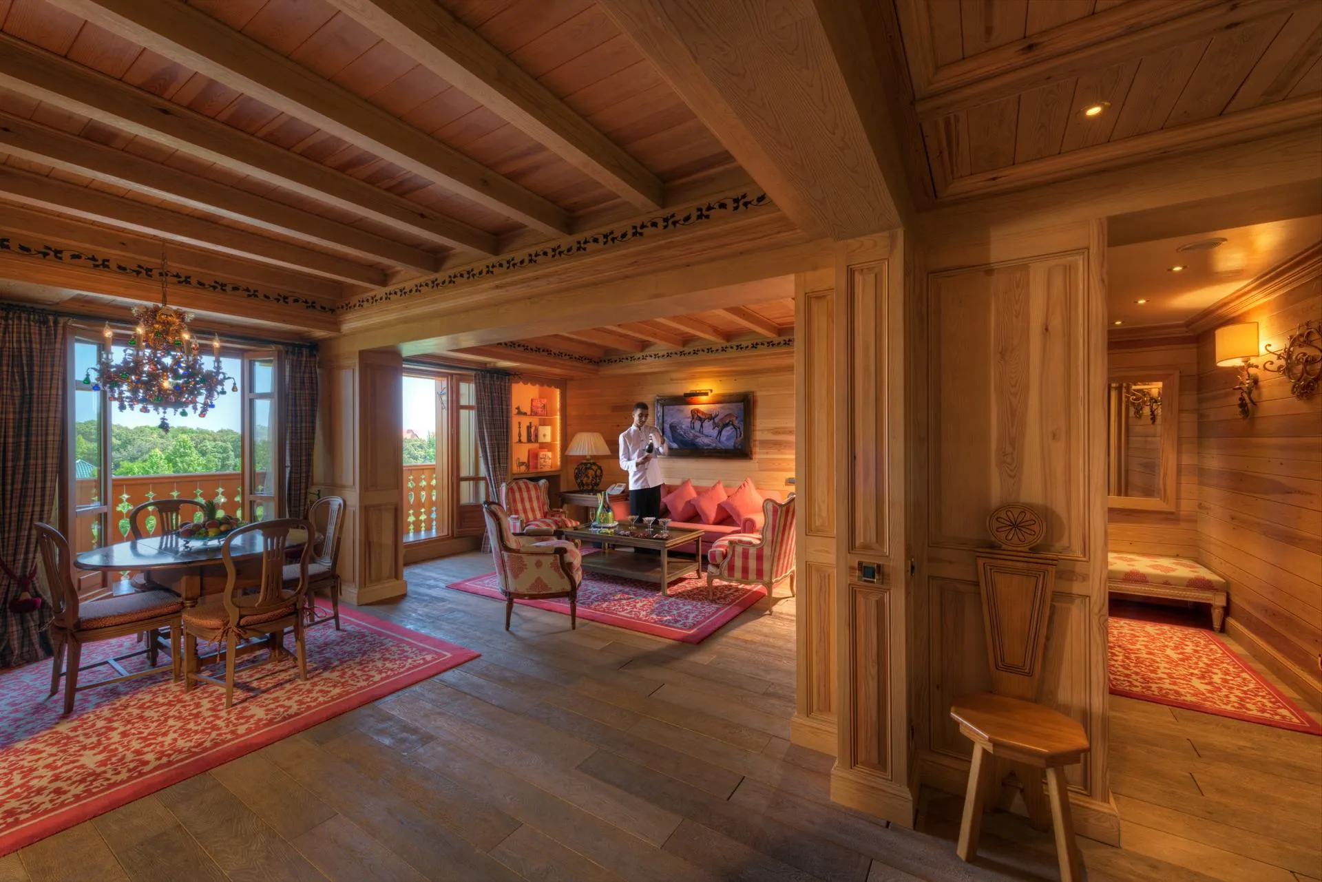 Intérieur en bois avec salon, table à manger et personne debout près d'une cheminée