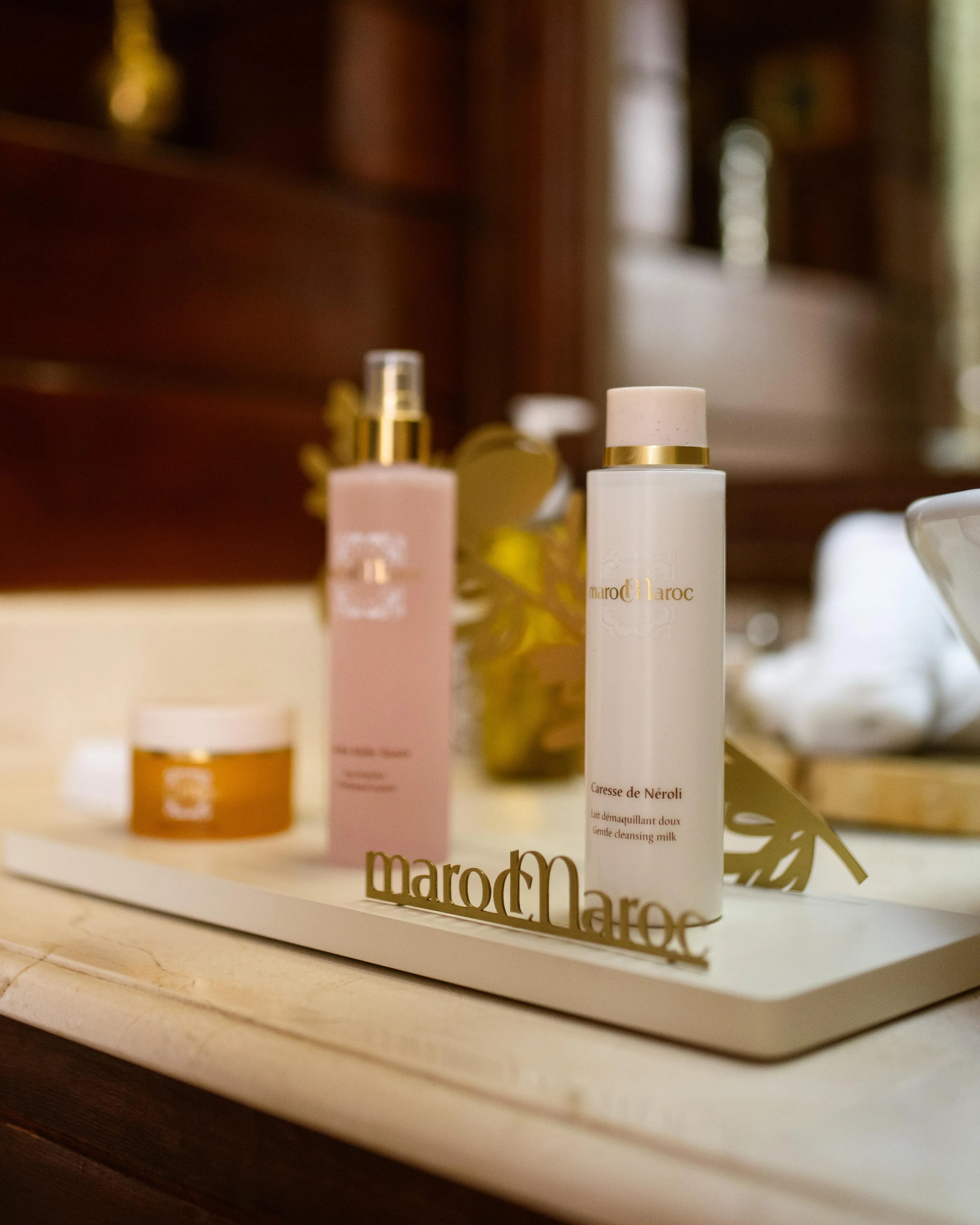 Deux flacons de produits cosmétiques de la marque MarocMaroc posés sur une surface en marbre
