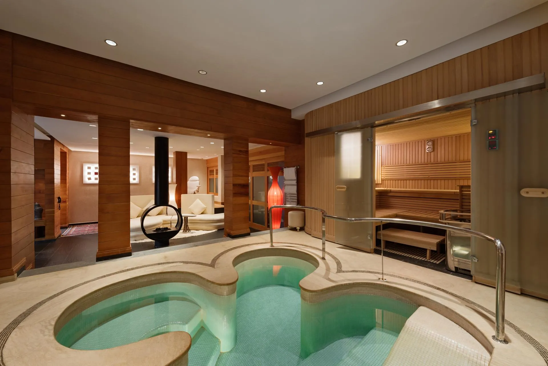Salle de spa avec piscine d'eau chaude, sauna et espace de repos en bois