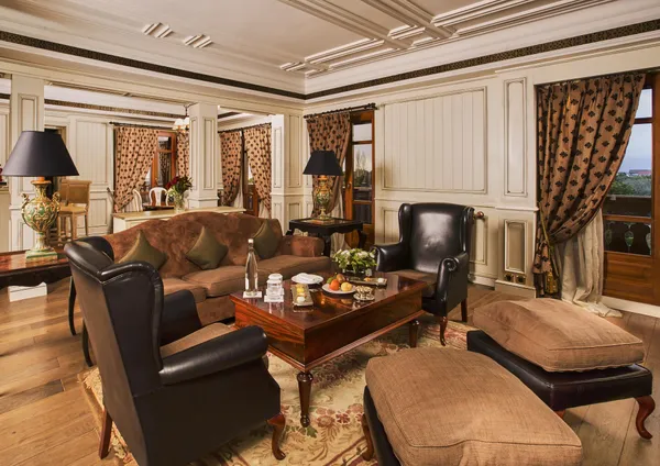 Salon élégant avec canapé en cuir marron, fauteuils en cuir noir, table basse en bois et décorations florales