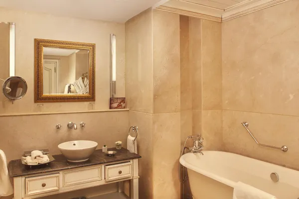 Salle de bain avec lavabo, miroir encadré, baignoire et accessoires de toilette